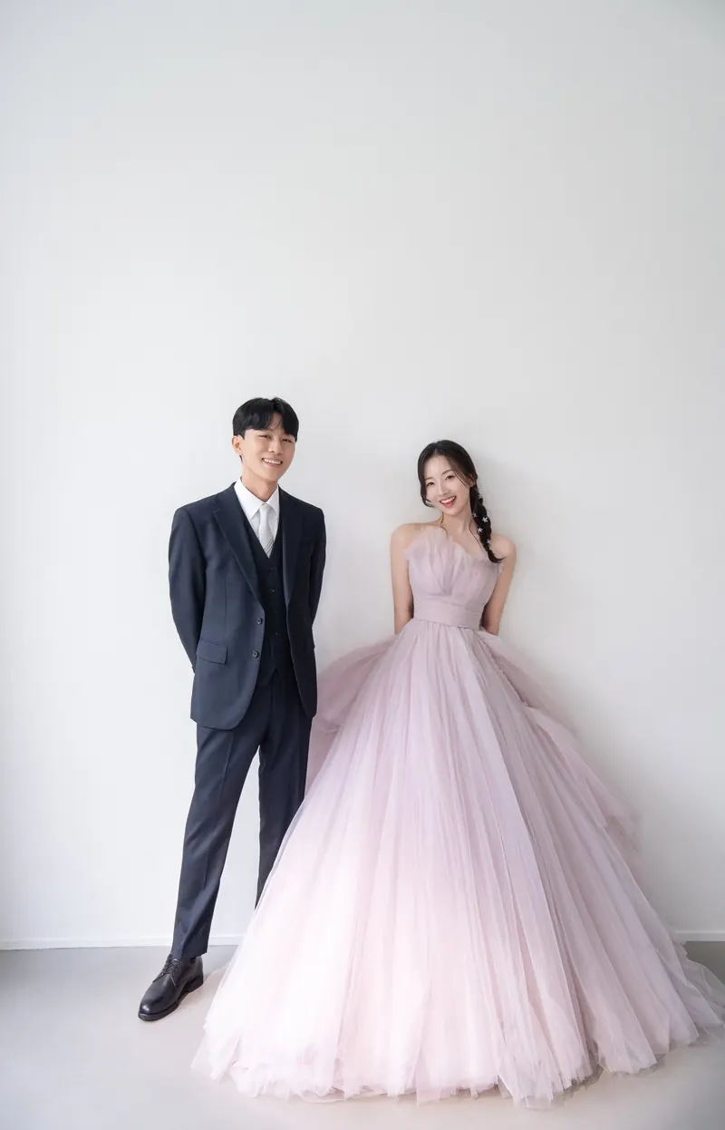 분홍 드레스와 턱시도를 입은 신랑 신부