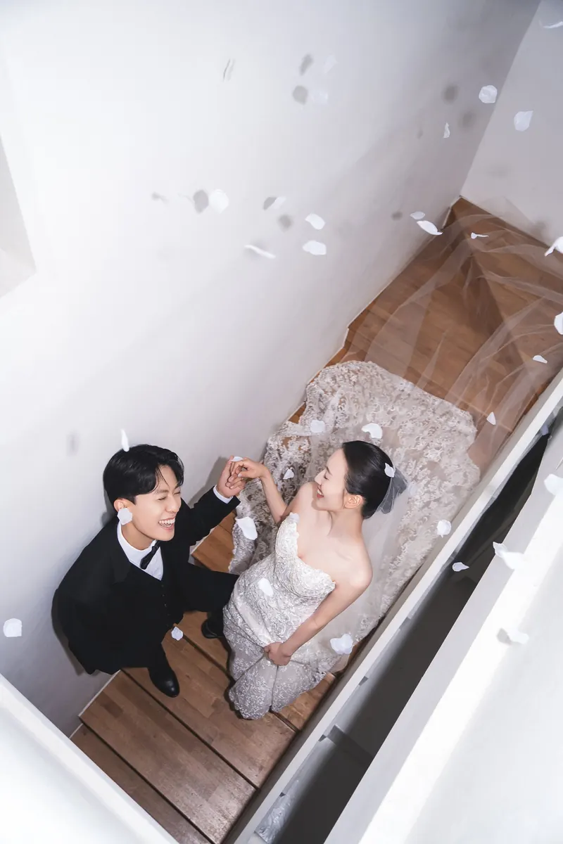 꽃잎이 흩날리는 계단 위 신랑 신부